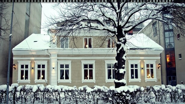 A two-story building with a symmetrical facade, large windows, and a snow-covered roof. - Hotel Kungsängstorg (Uppsala)