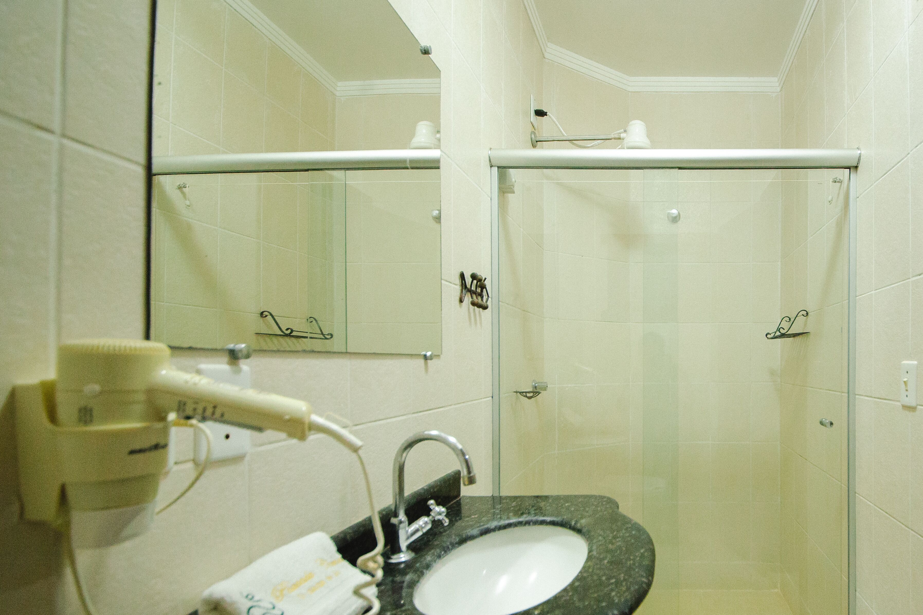 Ein Badezimmer mit Waschbecken, Spiegel und zwei Duschkabinen.
