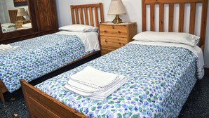 A hotel room with two single beds, wooden headboards, a nightstand with a lamp, and a mirror. - Bed&Breakfast Arcobaleno (Bologna)