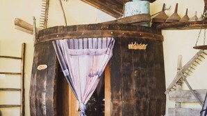 A rustic wooden structure with a small door, a wooden ladder, and a rustic chair. - B&B Pervinca (Rocca Grimalda)