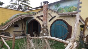 A rustic building with a stone facade, a wooden door, and a mural on the wall. - B&B Pervinca (Rocca Grimalda)