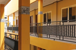 A multi-story building with yellow walls and black railings. - RedDoorz Plus near Palembang Square Mall (Palembang)