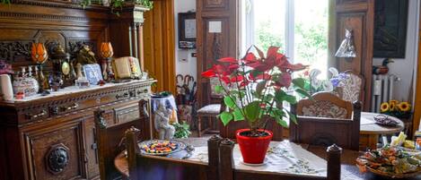 Un comedor tradicional con una mesa de madera, sillas y una planta en maceta roja.