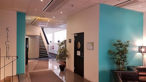 A modern lobby with a staircase, a reception desk, and a seating area. - Vandrarhem Uppsala Centralstation - Hostel (Uppsala)