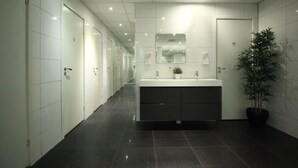 A modern bathroom with a large sink, mirror, and potted plant. - Vandrarhem Uppsala Centralstation - Hostel (Uppsala)