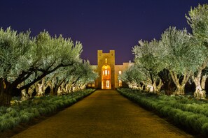 A pathway leading to a building with a tower and a lit entrance. - Château Roslane Boutique hôtel & Spa (Iqaddar)