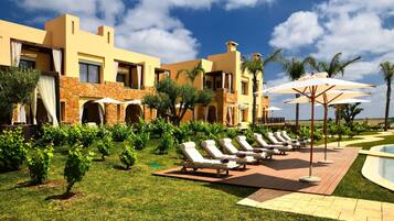 Um resort com piscina, espreguiçadeiras e um jardim bem cuidado.