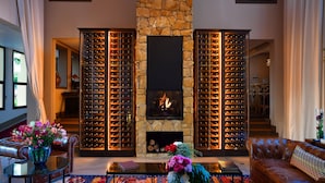 Una sala de estar acogedora con chimenea de piedra, sofás de cuero y una bodega de vino.
