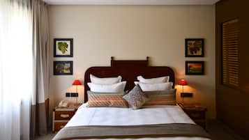 A hotel room with a large bed, two bedside tables, a nightstand, and a ceiling light.