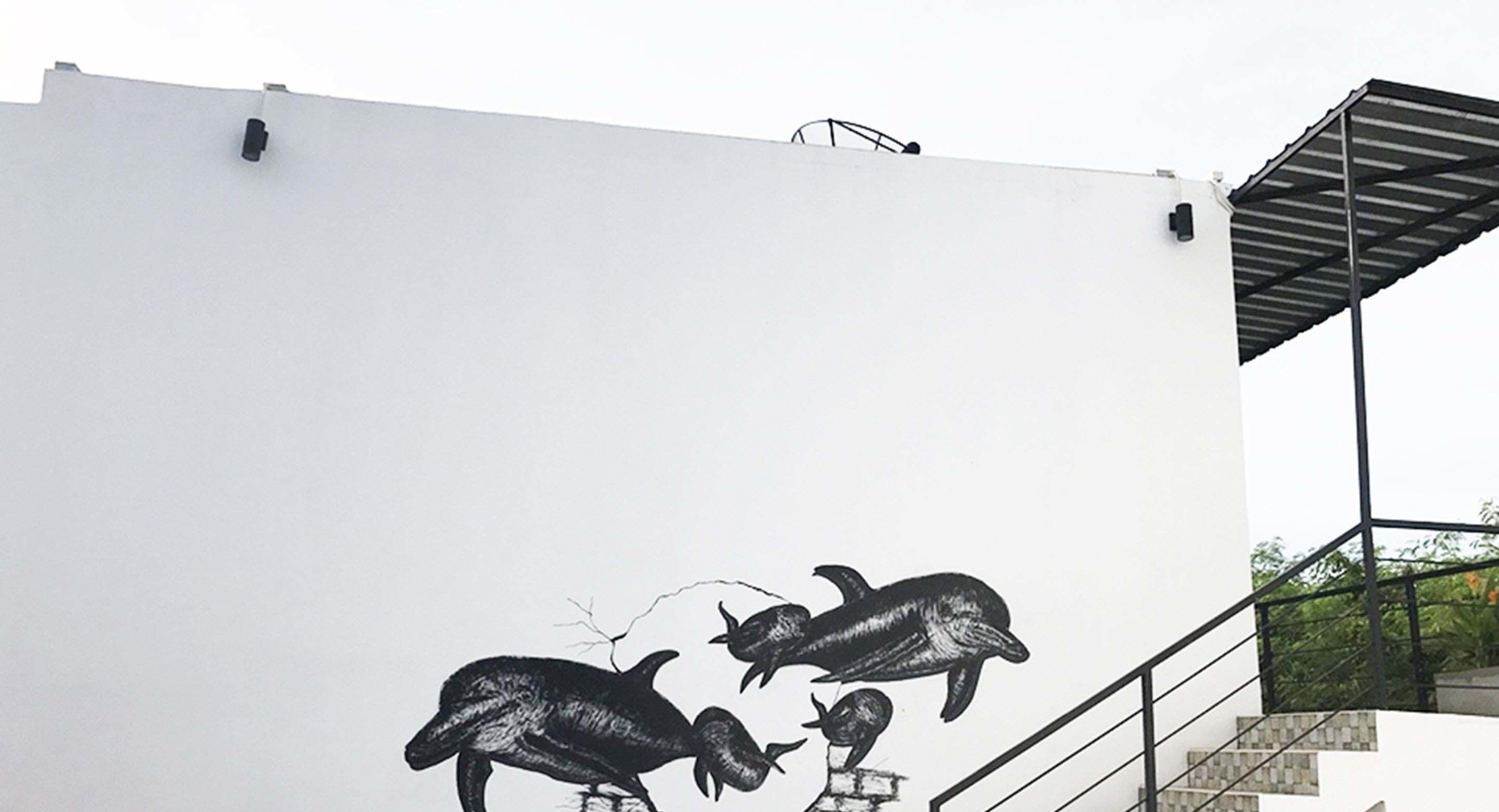 A white building with a mural of dolphins.