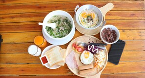 Una mesa de madera con un plato de sopa, huevos, salchichas y verduras.