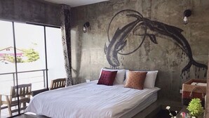 Quarto com cama grande, vista pela janela e painel na parede.