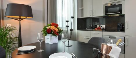 Un comedor moderno con una mesa redonda para dos personas, una lámpara y un jarrón de flores.