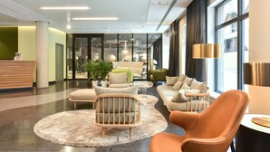 A modern lobby with a reception desk, seating area, and large windows. - Martin's All Suites (Ottignies-Louvain-la-Neuve)