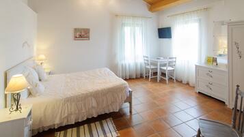 Ein Schlafzimmer mit Bett, Nachttisch, Lampe und Stuhl.