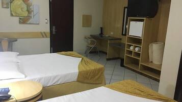 Hotellihuone, jossa on kaksi sänkyä, työpöytä, tuoli, televisio ja vaatekaappi.