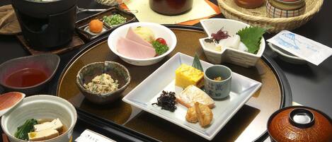 Presentación tradicional de comida japonesa con diversos platos y utensilios sobre una bandeja.