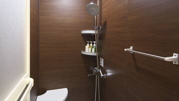 Un baño moderno y compacto con ducha, inodoro y estante de almacenamiento.