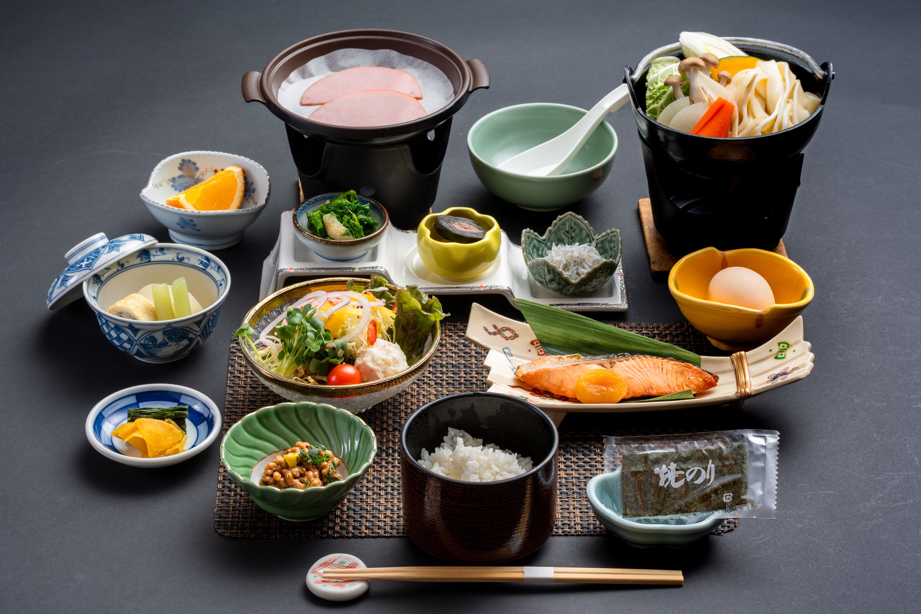 Ett urval av japanska rätter, inklusive en skål soppa, portionsskålar med ris och en tallrik med lax.