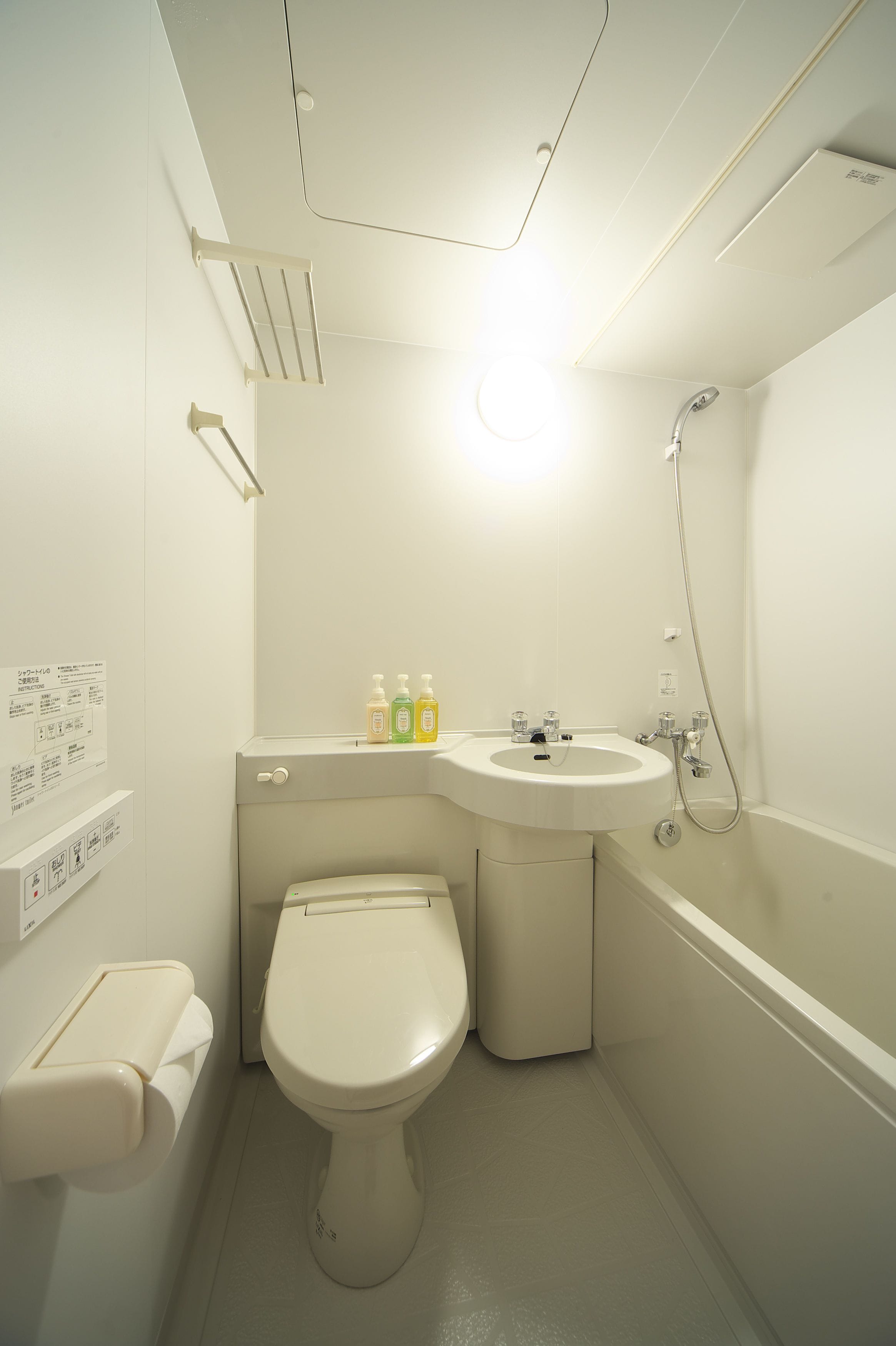 Een kleine badkamer met toilet, wastafel en douche.