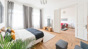 Une chambre à coucher moderne avec un grand lit, des tables de chevet, une commode et un dressing.