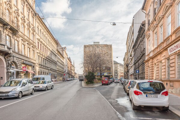 Una calle flanqueada por automóviles estacionados y edificios históricos.