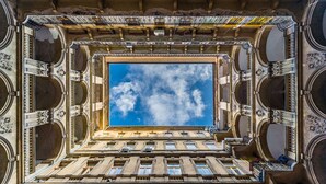 L’intérieur d’un bâtiment doté d’une grande verrière, de détails architecturaux raffinés et de nombreuses fenêtres.