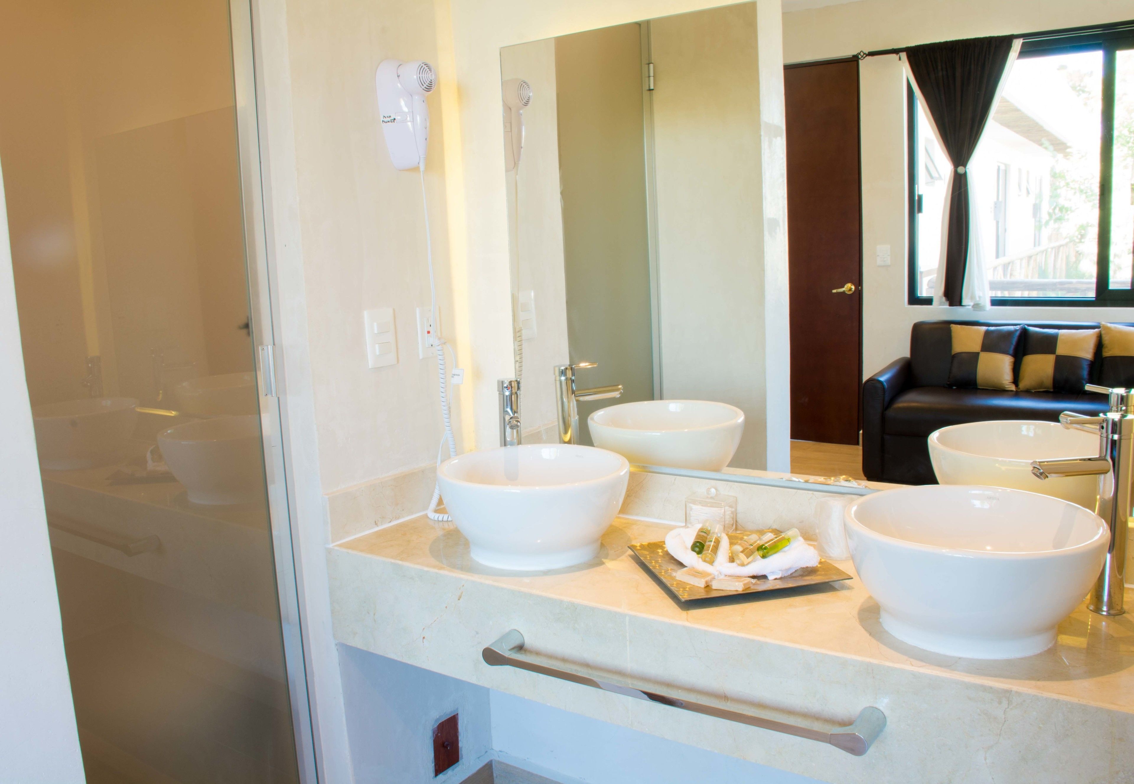 A bathroom with two white sinks, a mirror, and a towel rack.