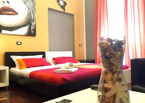 A hotel room with a bed, a nightstand, a vase with dried flowers, and a painting on the wall. - B&B G&G (Rome)