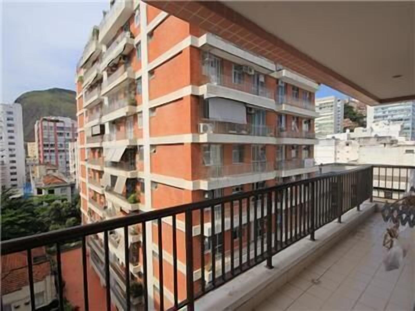 Un edificio residencial de varios pisos con balcones, piso de baldosas y vistas despejadas del entorno.