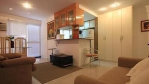 A compact living space with a kitchenette, a dining area, and a seating area. - GoHouse Torre do Barao 506 (Rio de Janeiro)