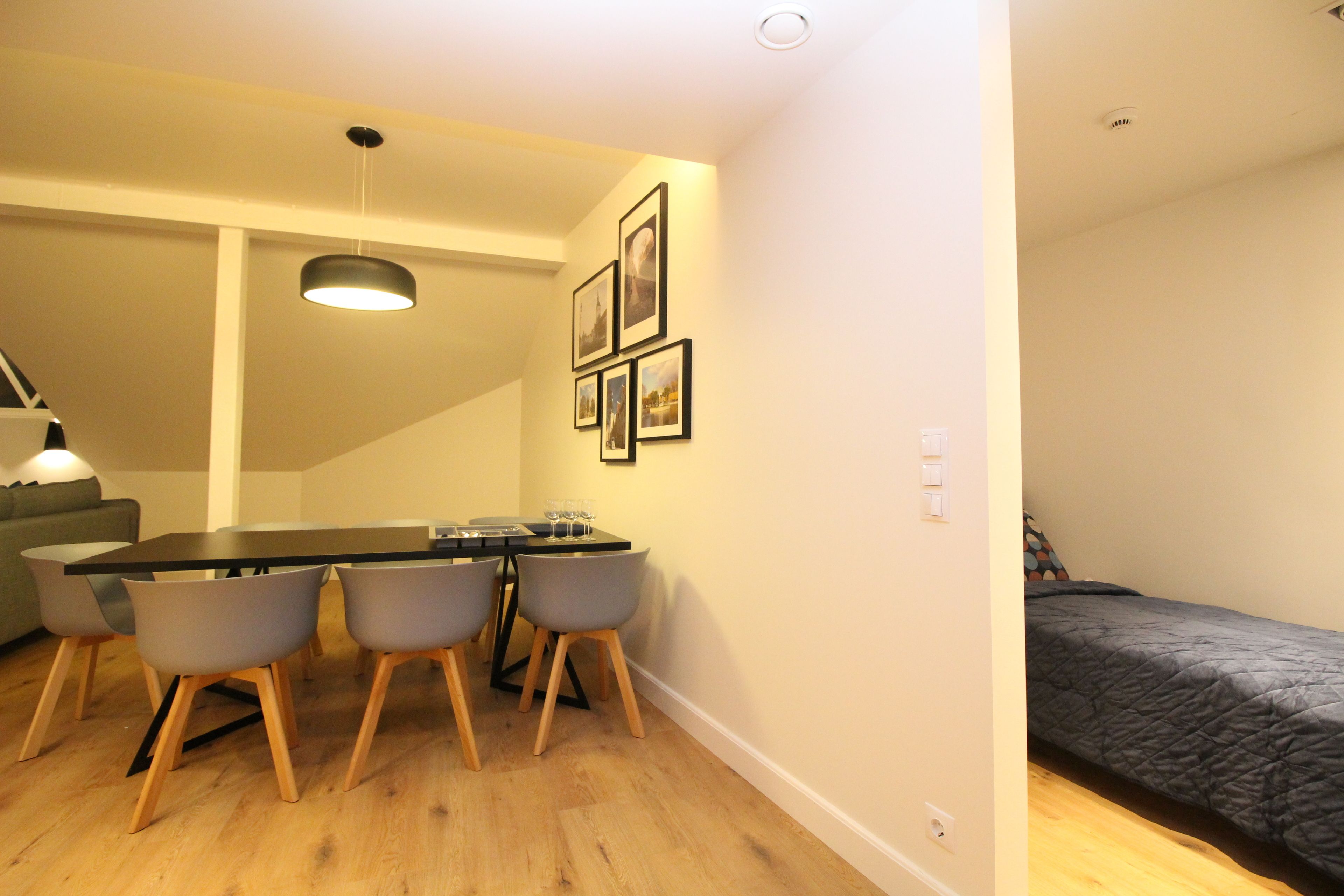 A compact living space with a dining area, a bed, and a staircase.
