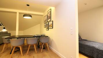 A compact living space with a dining area, a bed, and a staircase.