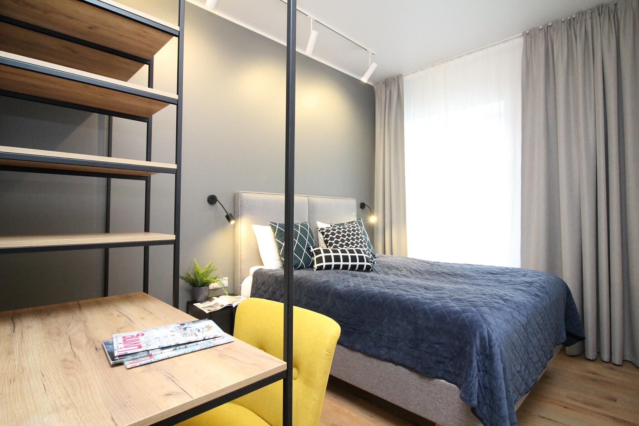 Un dormitorio moderno con cama, escritorio y silla.