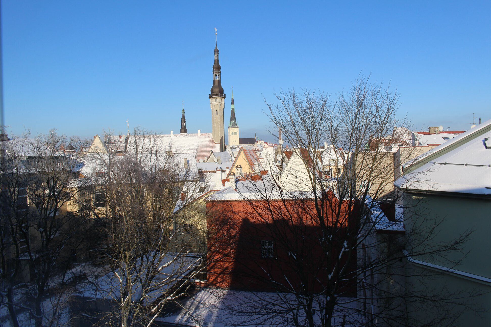 Eine Stadtansicht mit einem markanten Kirchturm und umliegenden Gebäuden.