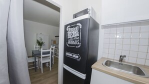 Een keuken met een zwarte koelkast, een houten aanrecht en een gootsteen.
