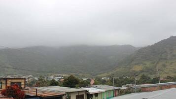 A residential area with houses and a hilly landscape in the background.