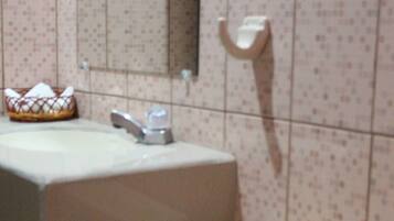 Un baño con inodoro, lavamanos y toallero.