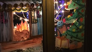 L’entrée d’un hôtel, ornée d’une fresque colorée, d’un sapin de Noël et d’une enseigne indiquant « HÔTEL ».