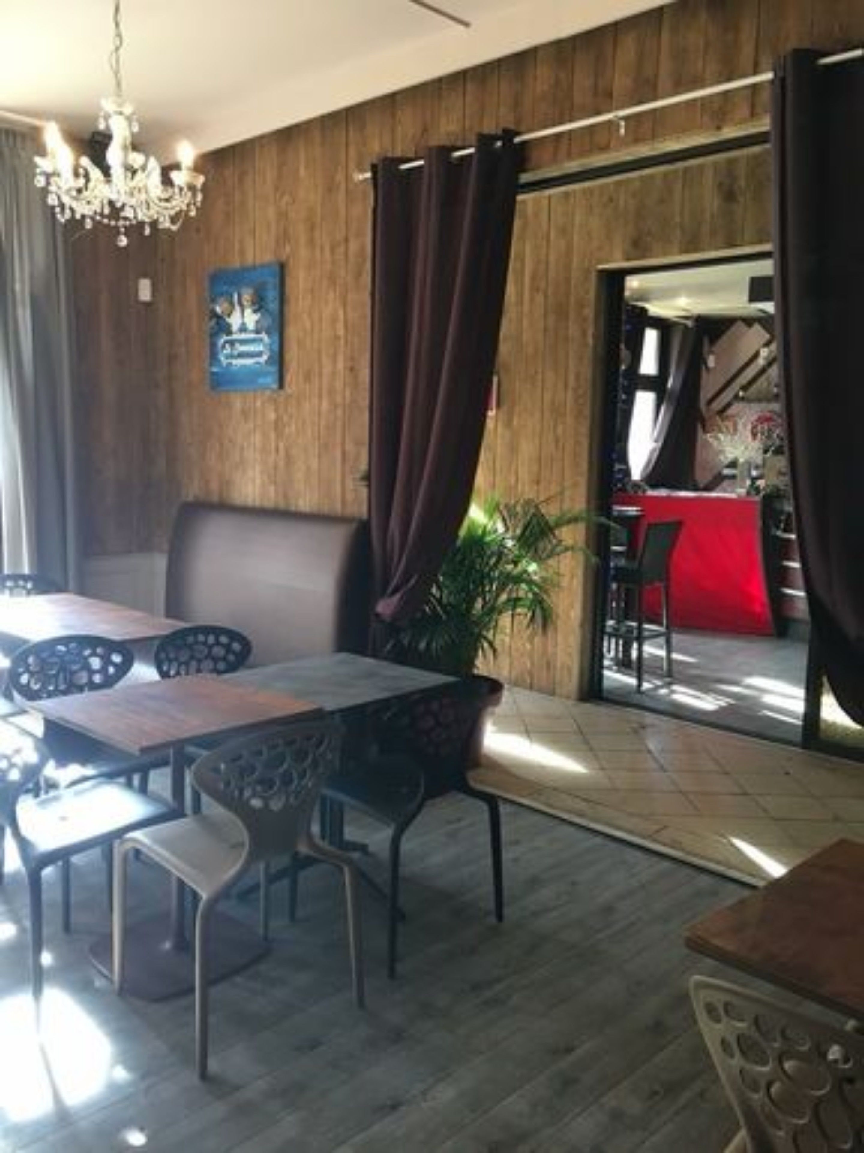 A restaurant with a wooden interior, a chandelier, and a view of the outside.