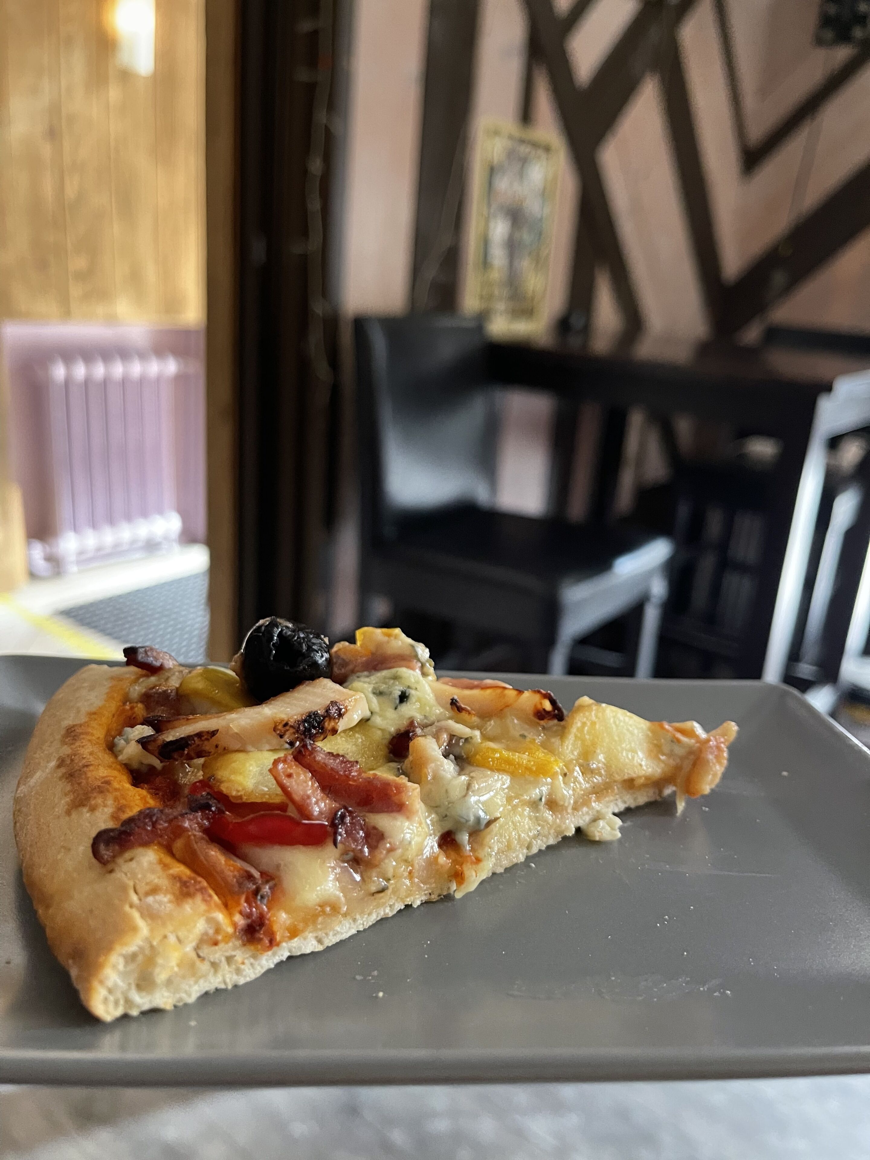 A slice of pizza on a gray plate.