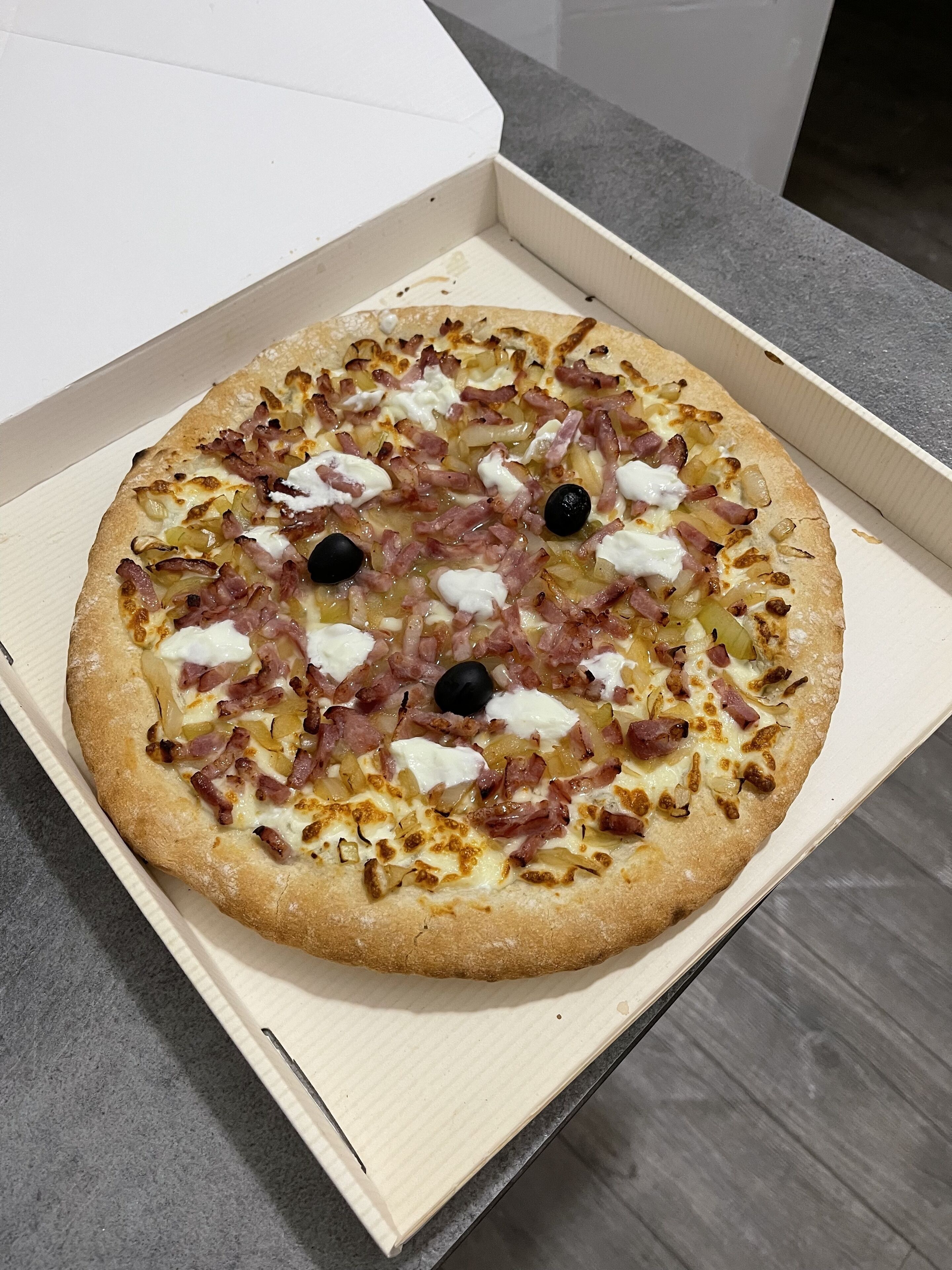 Une pizza dans une boîte en carton.