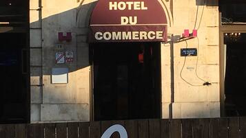 A building with a sign that reads "HOTEL DU COMMERCE."