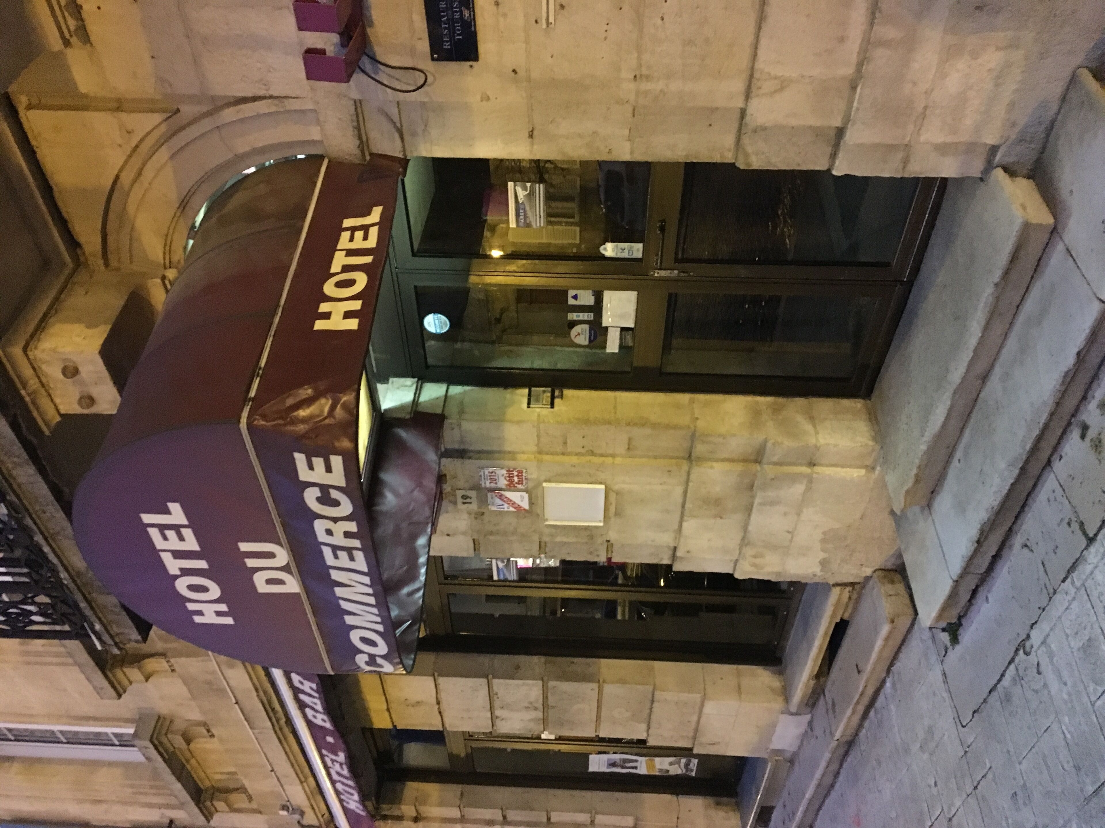 Een hotelschild met daarop 'HOTEL DU COMMERCE'.