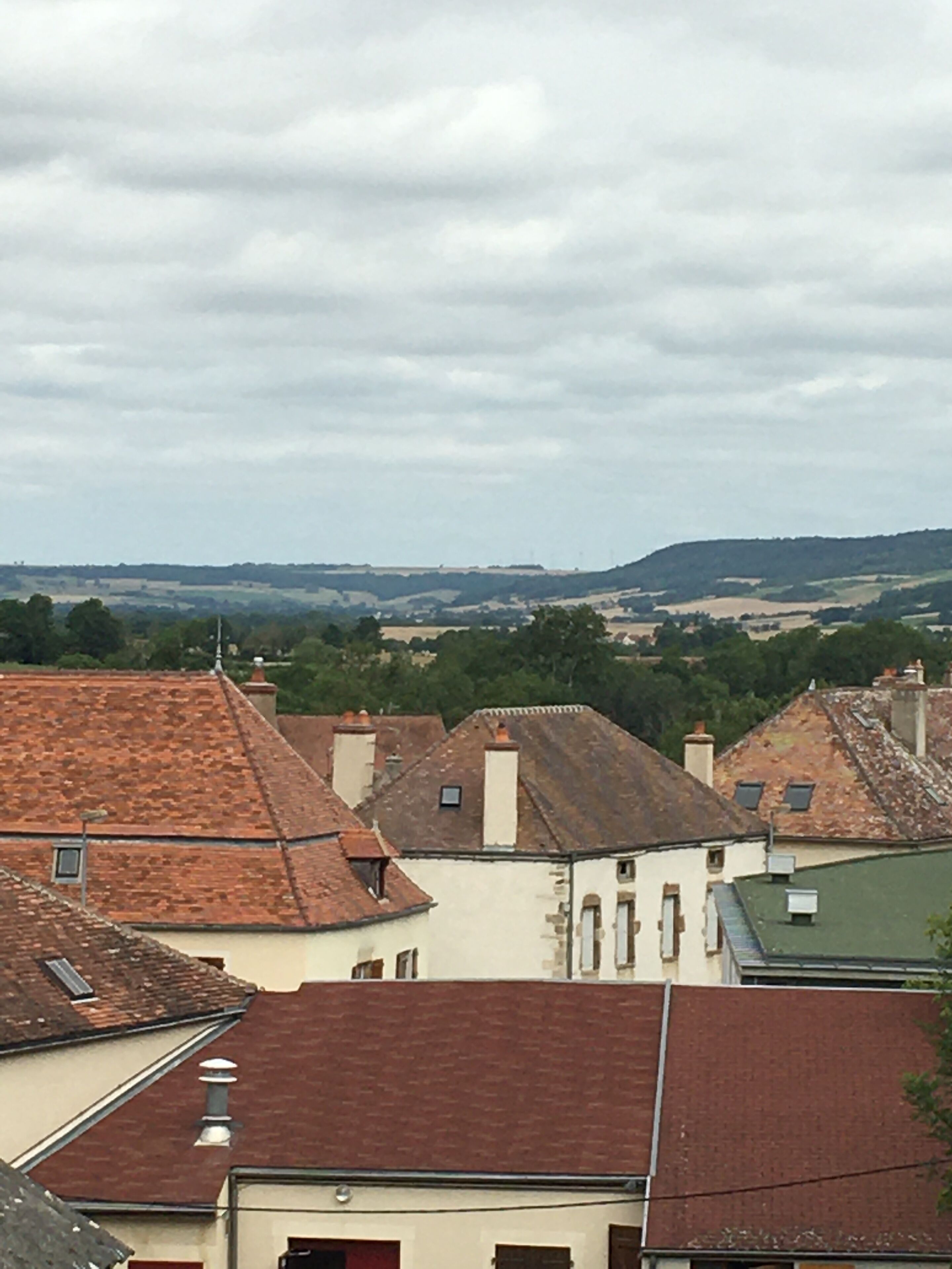 Vista de un pueblo con edificios tradicionales y un paisaje montañoso en la distancia.