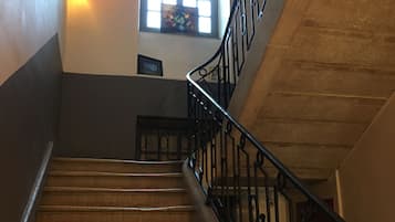 Una escalera de madera con barandillas de metal negro que conduce a una plataforma.