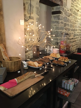A buffet setup with various food items, a bread basket, and a beverage dispenser.