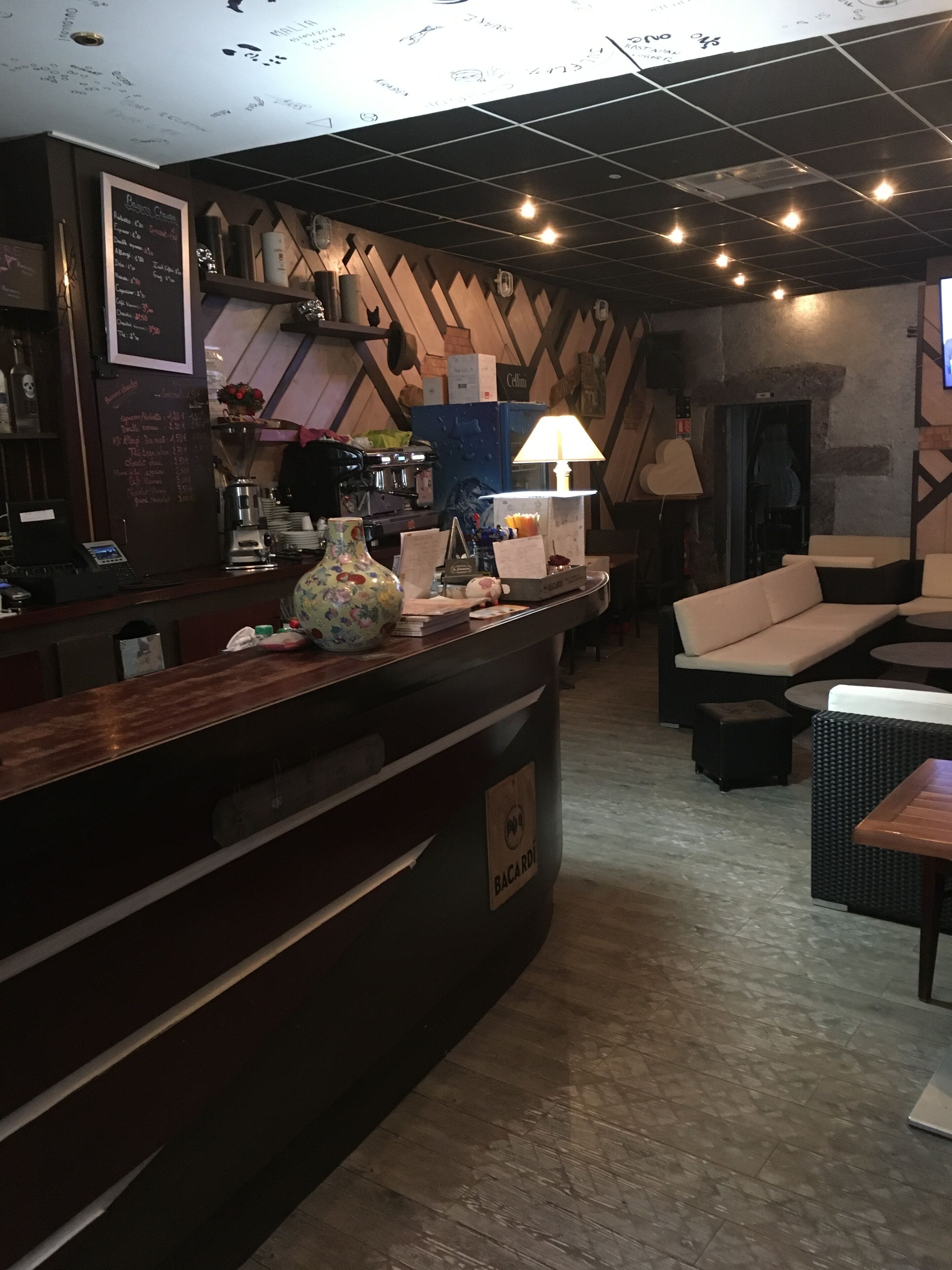 A bar area with a counter, seating, and a coffee machine.