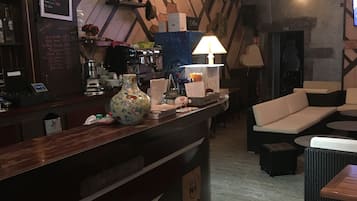 A bar area with a counter, seating, and a coffee machine.