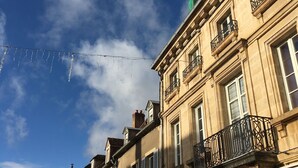 Un hôtel à la façade classique, ornée de nombreuses fenêtres et de balcons, et dont l’enseigne indique qu’il abrite un bar.